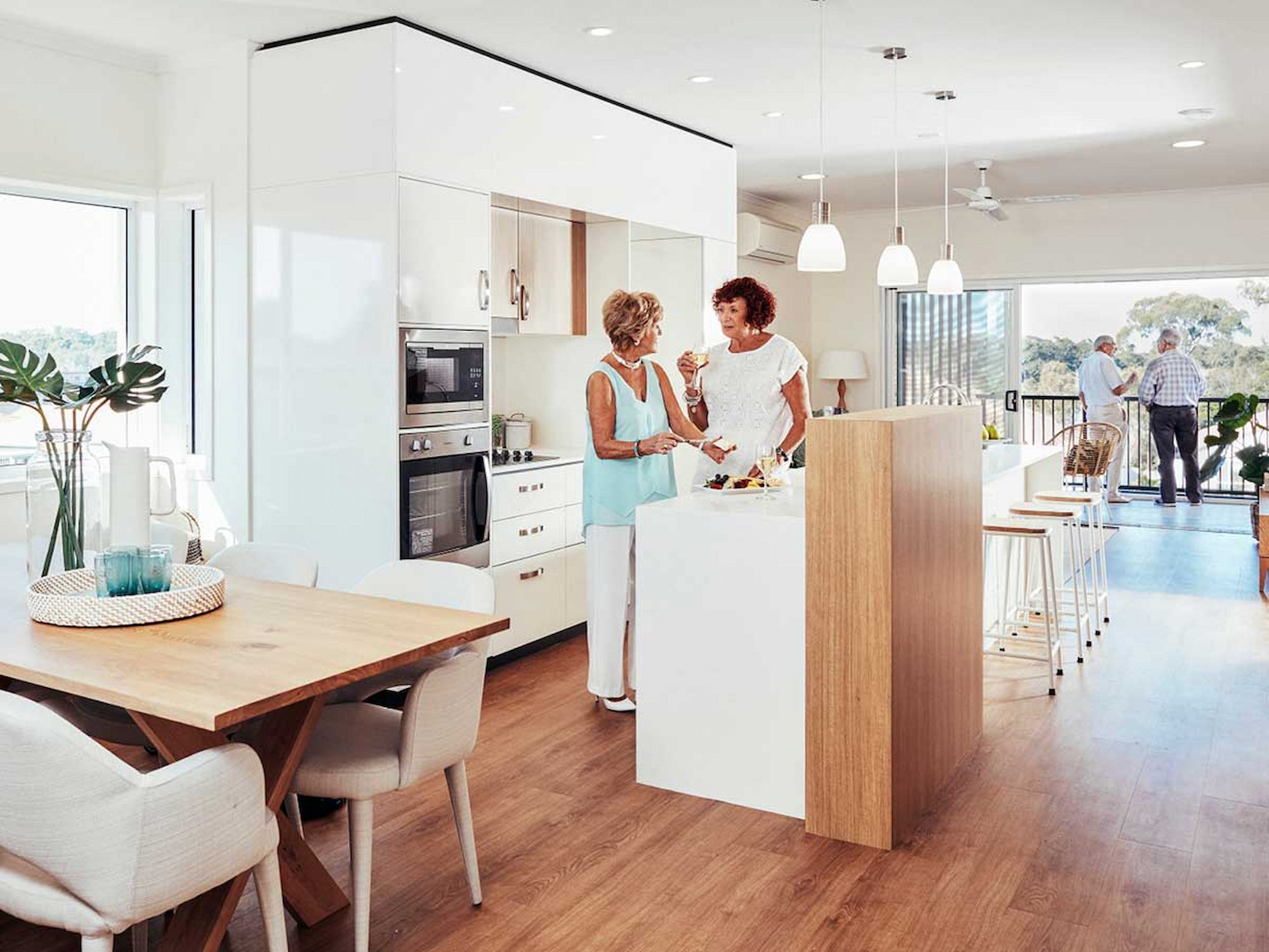 Residents chatting in kitchen in their villa